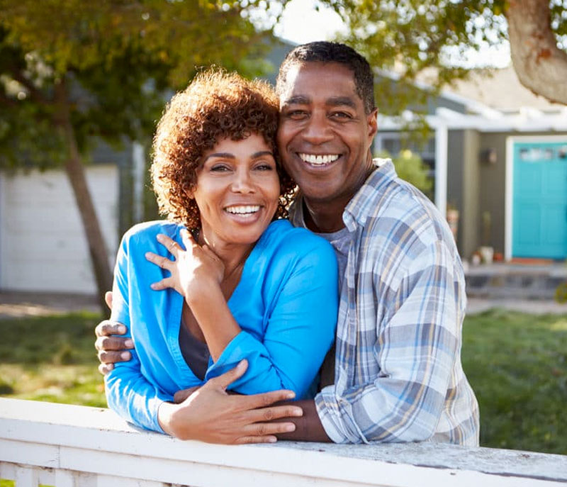 Senior couple in retirement standing outside smiling